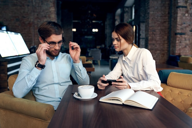 Zakelijke man en vrouw in een café communicatie telefoon werk