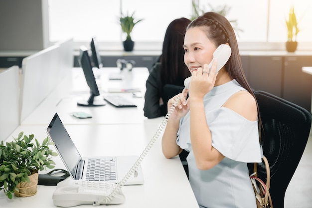 Zakelijke medewerker aan de telefoon om de klant op kantoor te helpen, een gelukkige glimlach naar de service