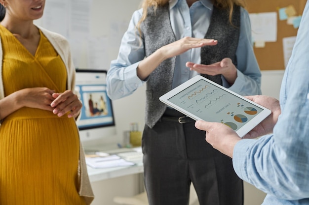 Zakelijke mensen gebruiken een tablet met financiële grafieken en bespreken rapporten in een team