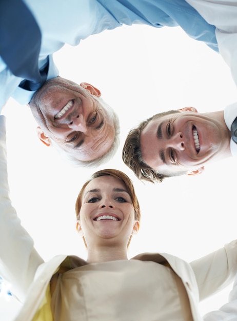 Zakelijke mensen glimlachen en verzamelen zich voor gelukkig succes samenwerking of teambuilding in portret Professionele collega's en gezicht in cirkel voor ondersteuning motivatie en solidariteit vanuit een lage hoek