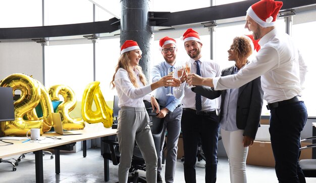 Zakelijke mensen vieren Happy New Year 2024 in een modern kantoor.