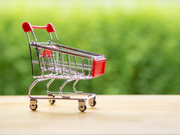 Zakelijke online verkoper, kleine winkelwagen op de houten tafel