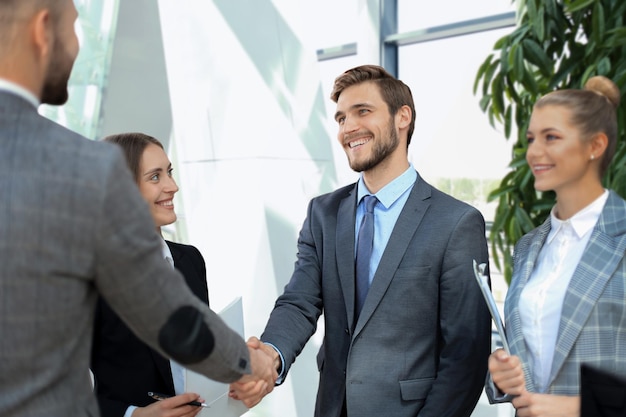 Zakelijke partners handenschudden over zakelijke objecten op de werkplek.