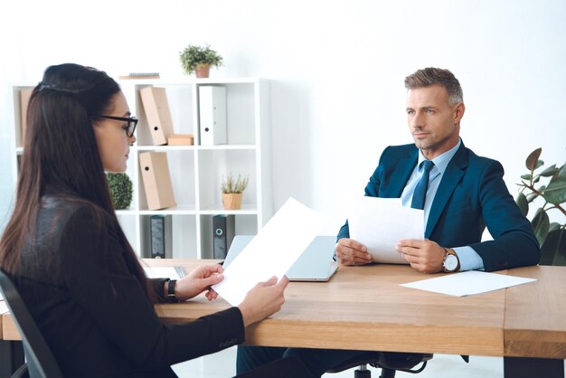 Zakelijke partners met papieren die werk bespreken op de werkplek op kantoor