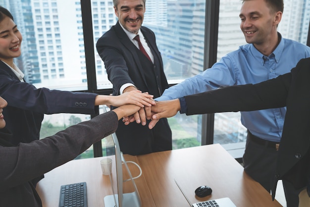 Zakelijke team senior executives en jonge werknemers slaan de handen ineen na een vergadering op kantoor