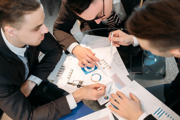 zakelijke teamcommunicatie. ideeën brainstormen. mannen bespreken documenten in kantoorwerkruimte