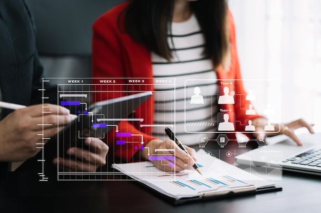 Zakelijke teamhand Projectmanager werkt en updatet taken en Gantt-grafiek die virtueel diagram plannen met smartphone, tablet en laptop op kantoor