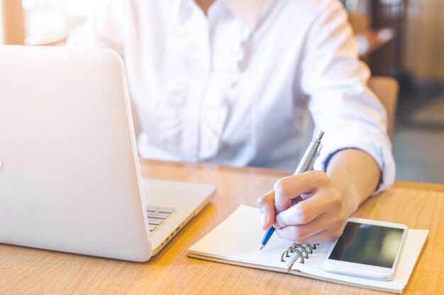 zakelijke vrouw hand schrijven op Kladblok met een pen.