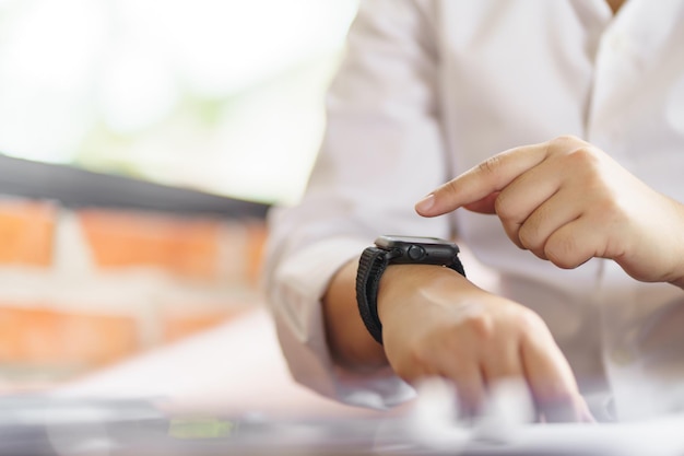 Zakelijke vrouw kijkt naar een slim horloge in het kantoor online verbinding gadget technologie