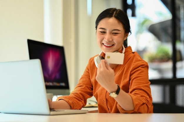 Zakelijke vrouw met een creditcard voor online winkelen en een moment van geluk in een modern kantoor