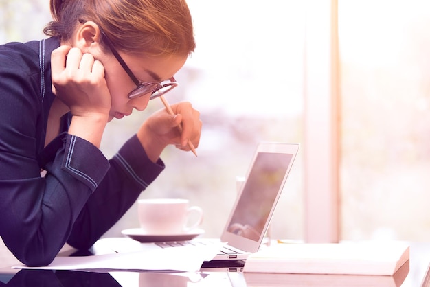 Zakelijke vrouw met een laptop op het bureau in het kantoor