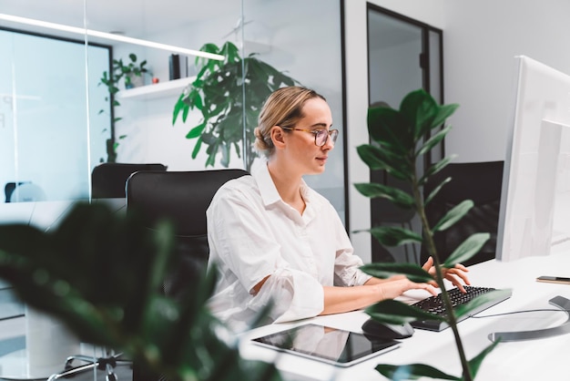 Zakelijke vrouw met een laptop terwijl ze op kantoor staat
