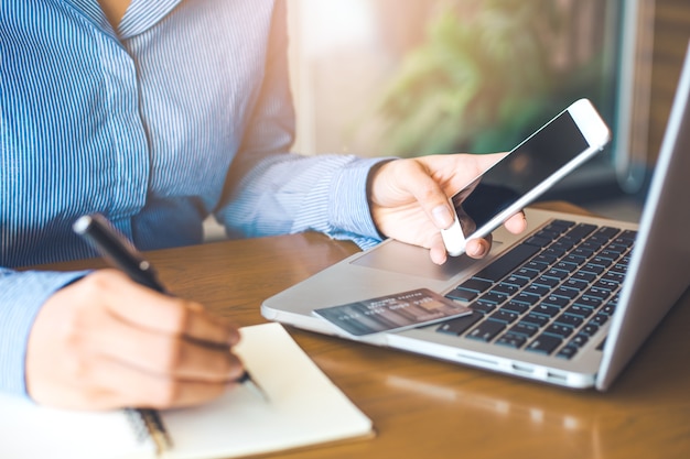 Zakelijke vrouwen gebruiken de telefoon en schrijven