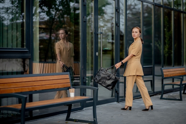 Zakelijke vrouwenstijl. Vrouw die met werkmap gaat werken. Portret van mooie glimlachende vrouw in stijlvolle kantoorkleding. Hoge resolutie.