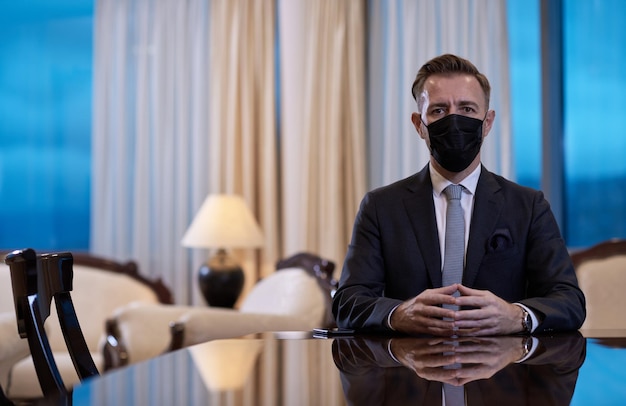 zakelijke zakenman met beschermend medisch gezichtsmasker op luxe kantoor