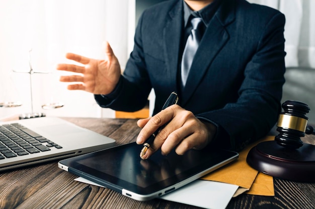 Zaken en advocaten bespreken contractpapieren met koperen schaal op bureau in kantoor Wet juridische diensten advies rechtvaardigheid en wet concept foto met filmkorreleffect