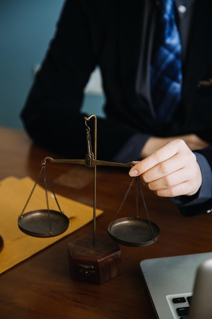 Zaken en advocaten bespreken contractpapieren met koperen schaal op bureau in kantoor Wet juridische diensten advies rechtvaardigheid en wet concept foto met filmkorreleffect