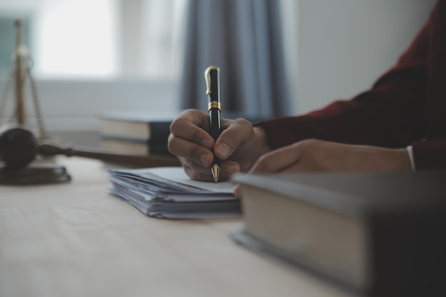 Zaken en advocaten bespreken contractpapieren met koperen schaal op bureau in kantoor Wet juridische diensten advies rechtvaardigheid en wet concept foto met filmkorreleffect