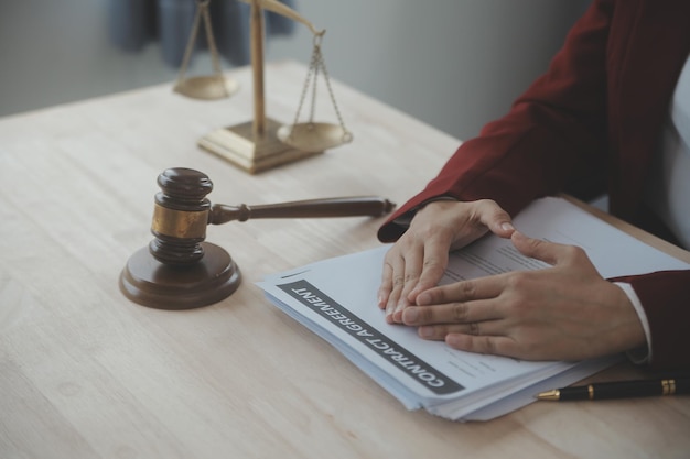 Zaken en advocaten bespreken contractpapieren met koperen schaal op bureau in kantoor Wet juridische diensten advies rechtvaardigheid en wet concept foto met filmkorreleffect