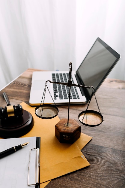 Zaken en advocaten bespreken contractpapieren met koperen schaal op bureau in kantoor Wet juridische diensten advies rechtvaardigheid en wet concept foto met filmkorreleffect