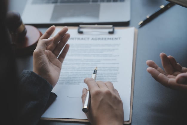 Zaken en advocaten bespreken contractpapieren met koperen schaal op bureau in kantoor Wet juridische diensten advies rechtvaardigheid en wet concept foto met filmkorreleffect