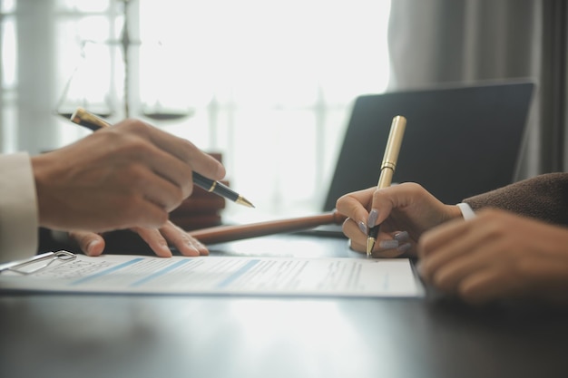 Zaken en advocaten bespreken contractpapieren met koperen schaal op bureau in kantoor Wet juridische diensten advies rechtvaardigheid en wet concept foto met filmkorreleffect