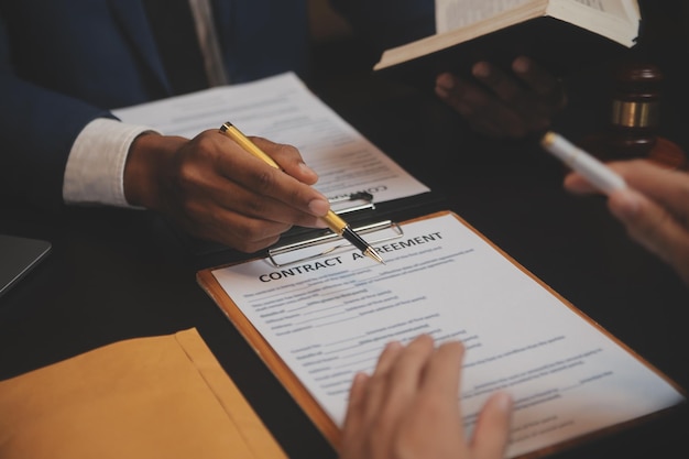 Zaken en advocaten bespreken contractpapieren met koperen schaal op bureau in kantoor Wet juridische diensten advies rechtvaardigheid en wet concept foto met filmkorreleffect