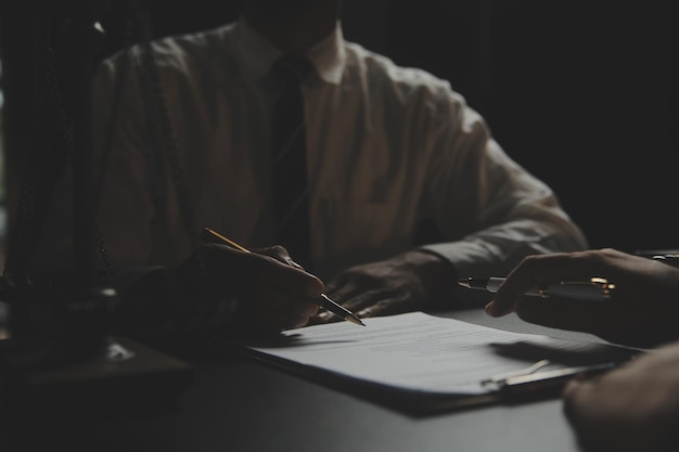 Zaken en advocaten bespreken contractpapieren met koperen schaal op bureau in kantoor Wet juridische diensten advies rechtvaardigheid en wet concept foto met filmkorreleffect