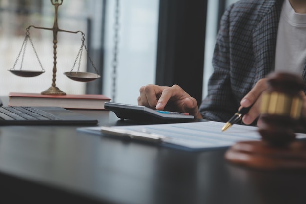 Zaken en advocaten bespreken contractpapieren met koperen schaal op bureau in kantoor Wet juridische diensten advies rechtvaardigheid en wet concept foto met filmkorreleffect