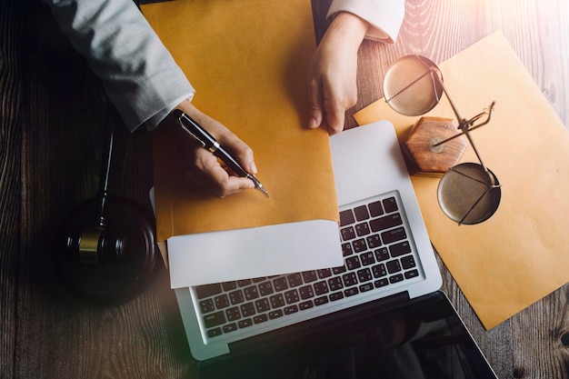 Zaken en advocaten bespreken contractpapieren met koperen schaal op bureau in kantoor Wet juridische diensten advies rechtvaardigheid en wet concept foto met filmkorreleffect