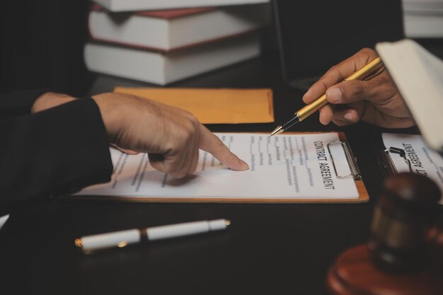 Zaken en advocaten bespreken contractpapieren met koperen schaal op bureau in kantoor Wet juridische diensten advies rechtvaardigheid en wet concept foto met filmkorreleffect