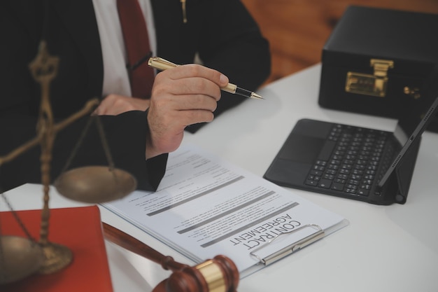 Zaken en advocaten bespreken contractpapieren met koperen schaal op bureau in kantoor Wet juridische diensten advies rechtvaardigheid en wet concept foto met filmkorreleffect