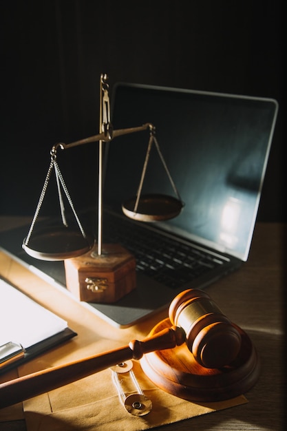 Zaken en advocaten bespreken contractpapieren met koperen schaal op bureau in kantoor Wet juridische diensten advies rechtvaardigheid en wet concept