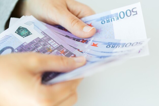 zaken, financiën, sparen, bankieren en mensenconcept - close-up van vrouwenhanden die euro geld tellen