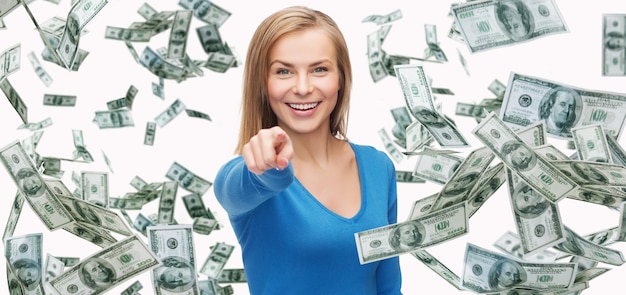 zaken, geld, financiën, mensen en bankconcept - glimlachende vrouw met dollar contant geld wijzende vinger op jou