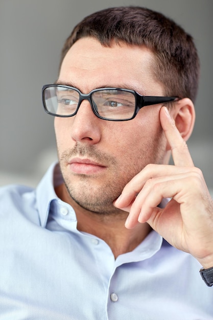 zaken, mensen en werkconcept - portret van zakenman in oogglazen op kantoor