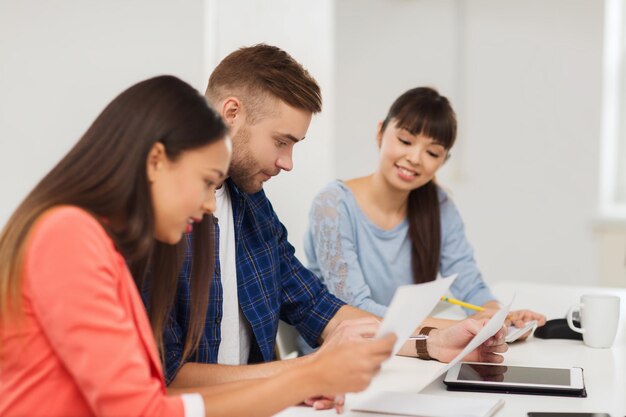 zaken, opstarten, onderwijs en mensenconcept - gelukkig creatief team of studenten die op kantoor werken