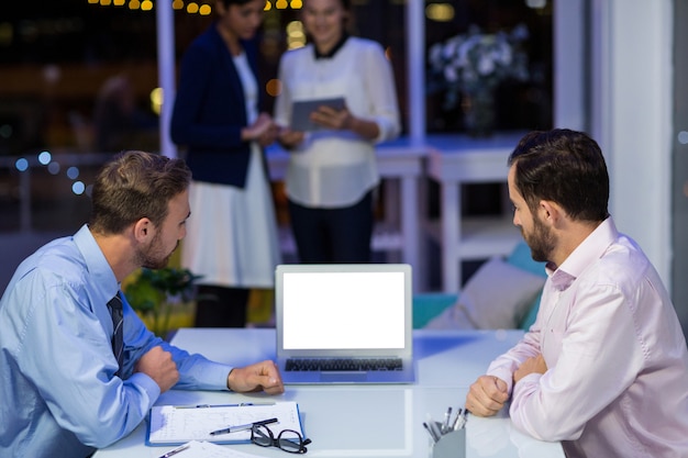 Zakenlieden die aan laptop in conferentieruimte werken