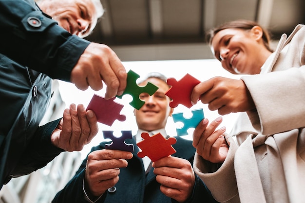 Foto zakenlieden die samenwerken om een puzzel op te bouwen als teamwerkpartnerschap en integratieconcept