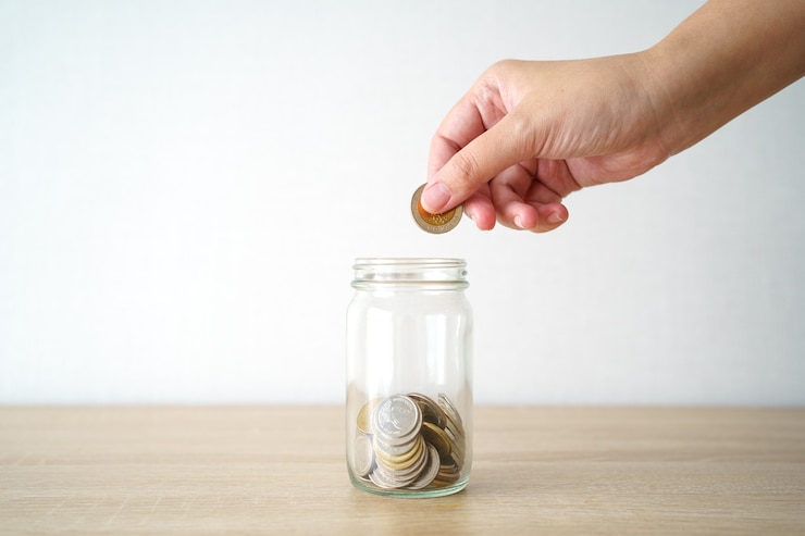 Foto zakenlieden doe de munt in een glazen pot om geld te besparen, geld te besparen op investeringen,