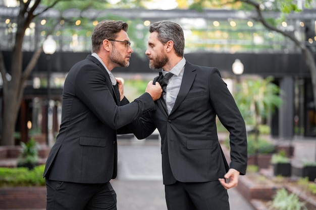 Zakenlieden vechten buitenshuis boze oneens mannen partners zakelijke concurrentie zakenlieden hebben conf