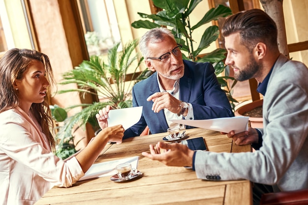 Zakenlunch drie mensen in het restaurant aan tafel bespreken project geconcentreerd team