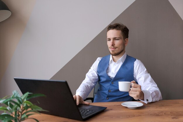 Zakenman aan het werk Man aan het werk op laptop zittend aan houten tafel