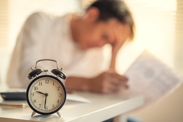 Foto zakenman benadrukt en bezorgd over de late tijd om het werkproject te beëindigen