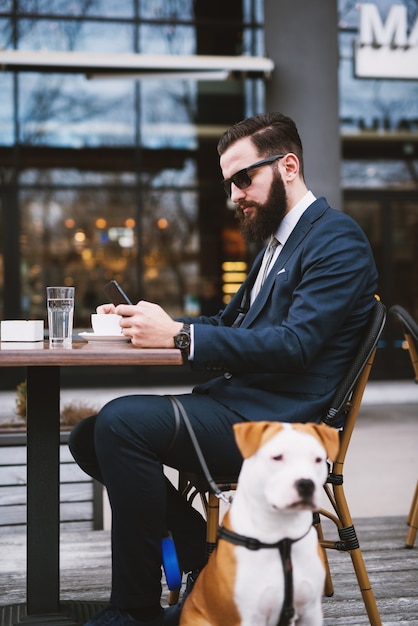 Zakenman bij coffeeshop met hond. Beste vrienden in café.