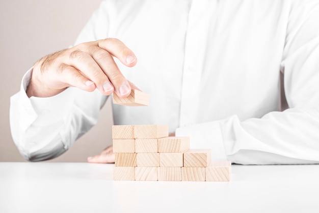 Zakenman bouwt een ladder van houten blokken