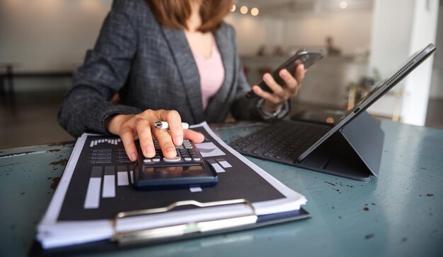 Zakenman die aan bureaubureau werkt met het gebruik van een rekenmachine om xA . te berekenen