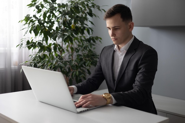 Zakenman die aan laptop in het bureau werkt