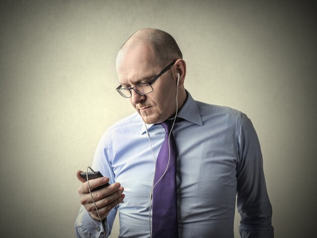 Zakenman die aan muziek op oortelefoons luistert