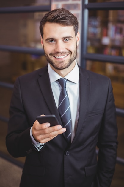 Zakenman die cellphone in bureau gebruikt